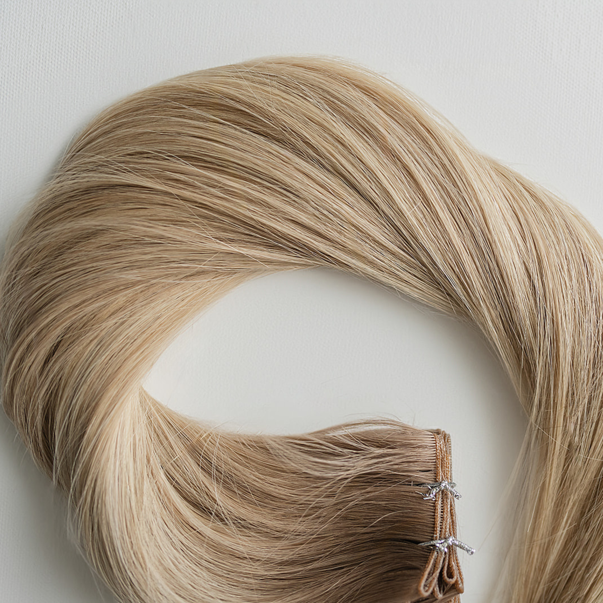 Ellie color Siren Hair Extensions featuring a neutral/cool Level 9 base with piano-keyed dimensional ends, including Level 9 cool/pearl lowlights and Level 10 neutral blonde highlights. Ideal for natural blondes seeking subtle dimension.