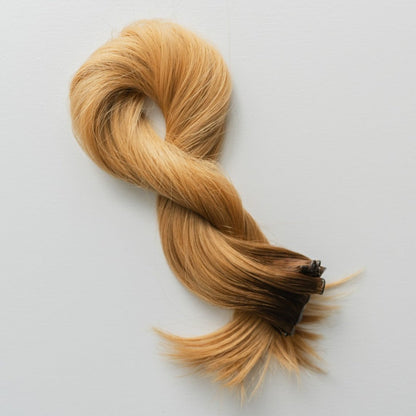 Hannah color Siren Hair Extensions featuring a warm Level 7 base with Level 9 warm copper blonde ends, offering a solid color with no dimension. Ideal for creating vibrant copper redhead styles.