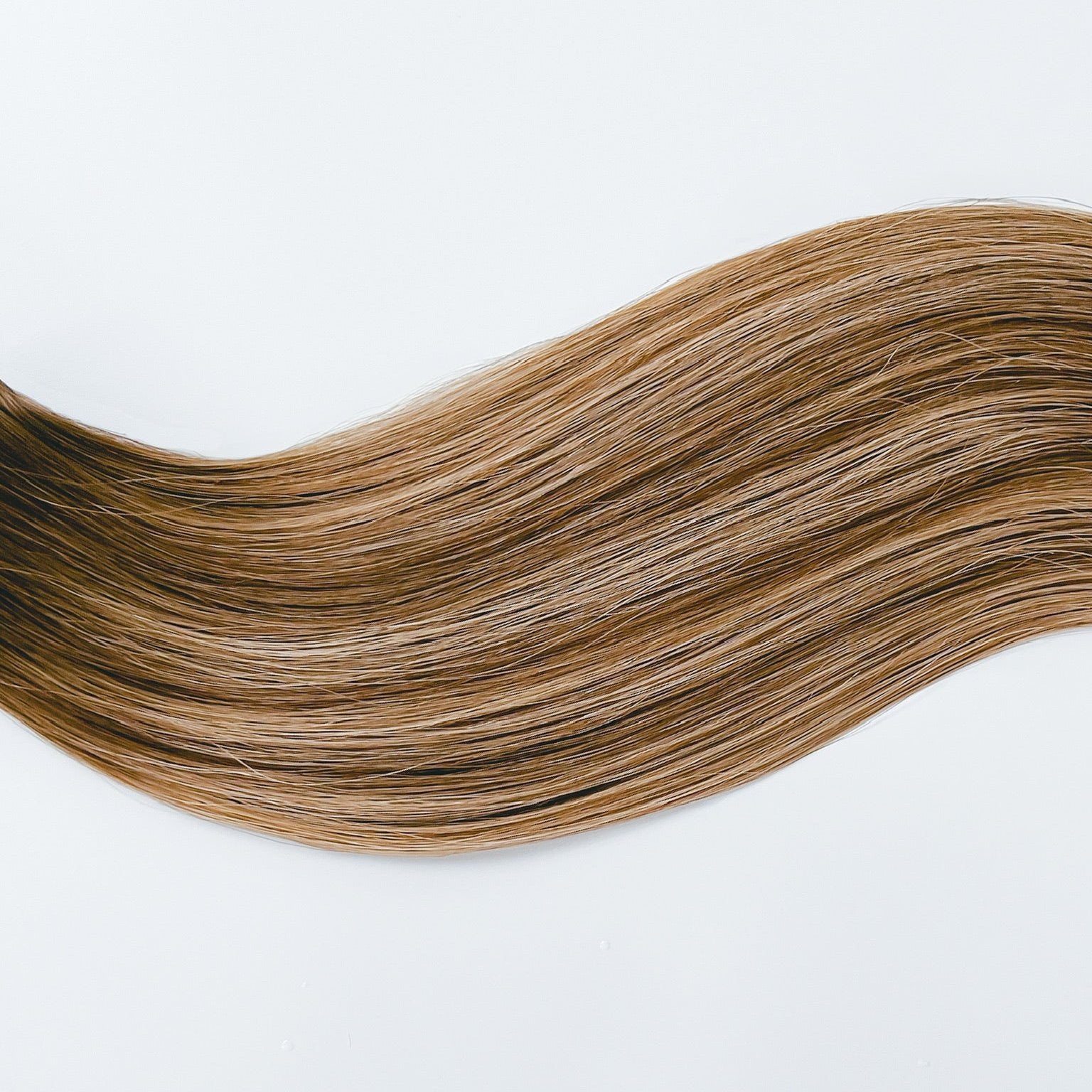 Kylee color Siren Hair Extensions featuring a neutral Level 7 base with piano-keyed dimensional ends, including neutral Level 7 lowlights and champagne blonde Level 9 highlights. Ideal for natural brunettes seeking a subtle bronde effect.