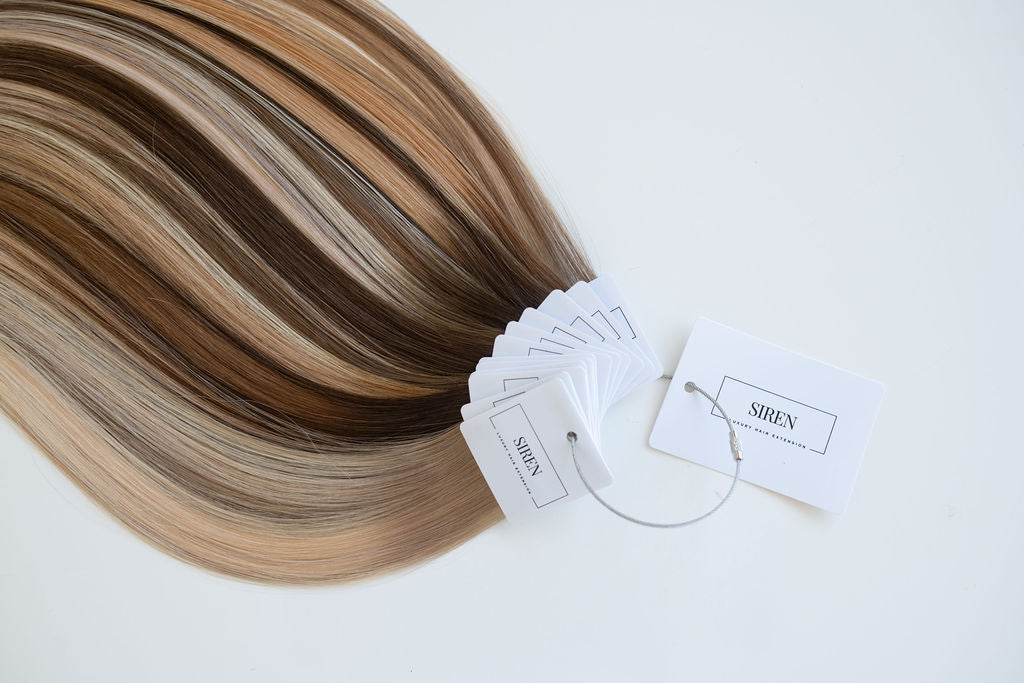 Hair swatch ring from Siren Luxury Hair Extensions showcasing a variety of blonde and brunette shades, highlighting the premium quality and natural texture of the Remy Human Hair extensions.