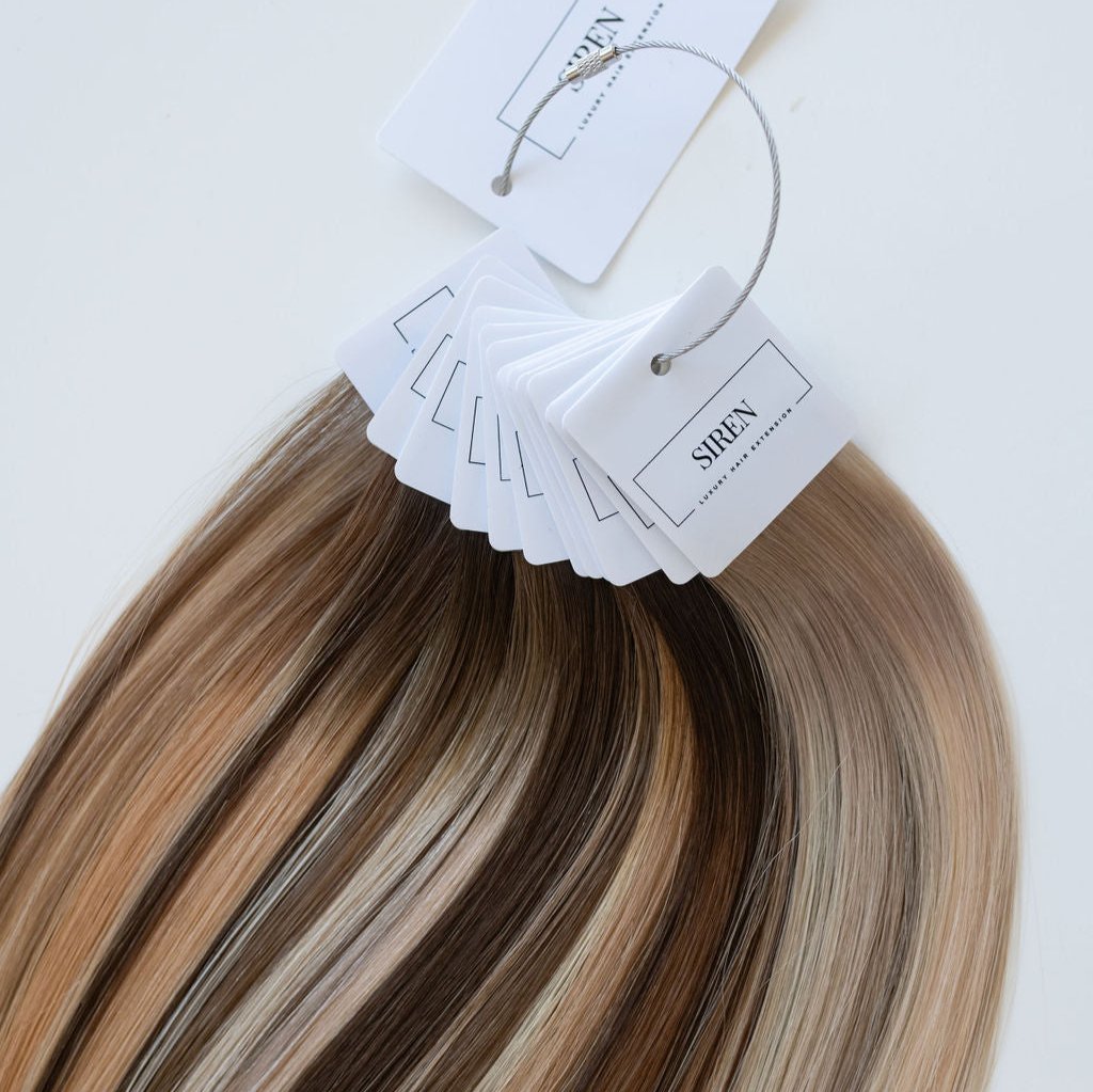 Siren Hair Extensions swatch ring showcasing a variety of premium genius weft extension shades, including an array of blondes, brunettes, and dimensional tones. Ideal for professional stylists to accurately match and select hair extension colors.